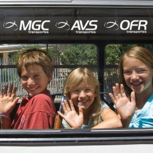 Imagem do site institucional,  3 crianças acenando à janela de um autocarro| © MGC Transportes